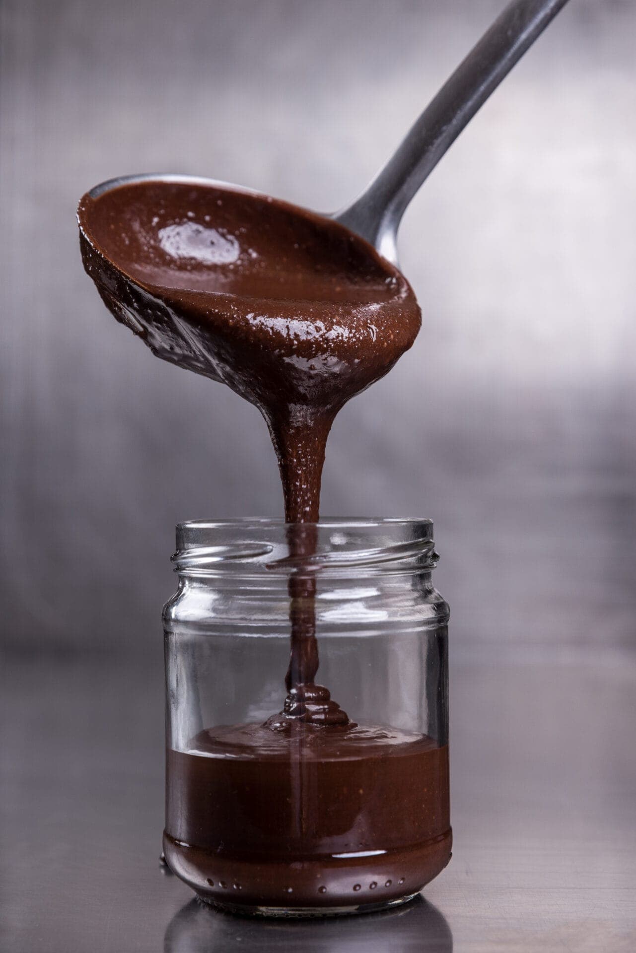 Chocolat fondu versé à la louche dans un pot de pâte à tartiner (© Marianne Louge)