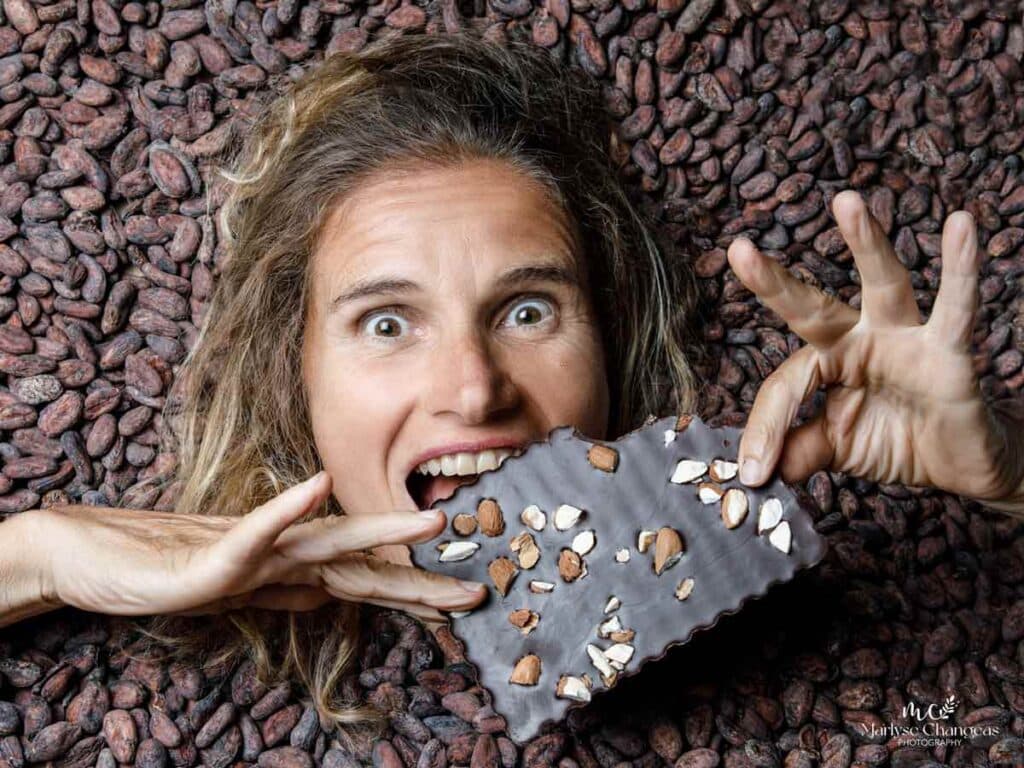 Patricia Tripotin, manager of the Frigoulette chocolate makers, bites into an almond chocolate bar surrounded by cocoa beans