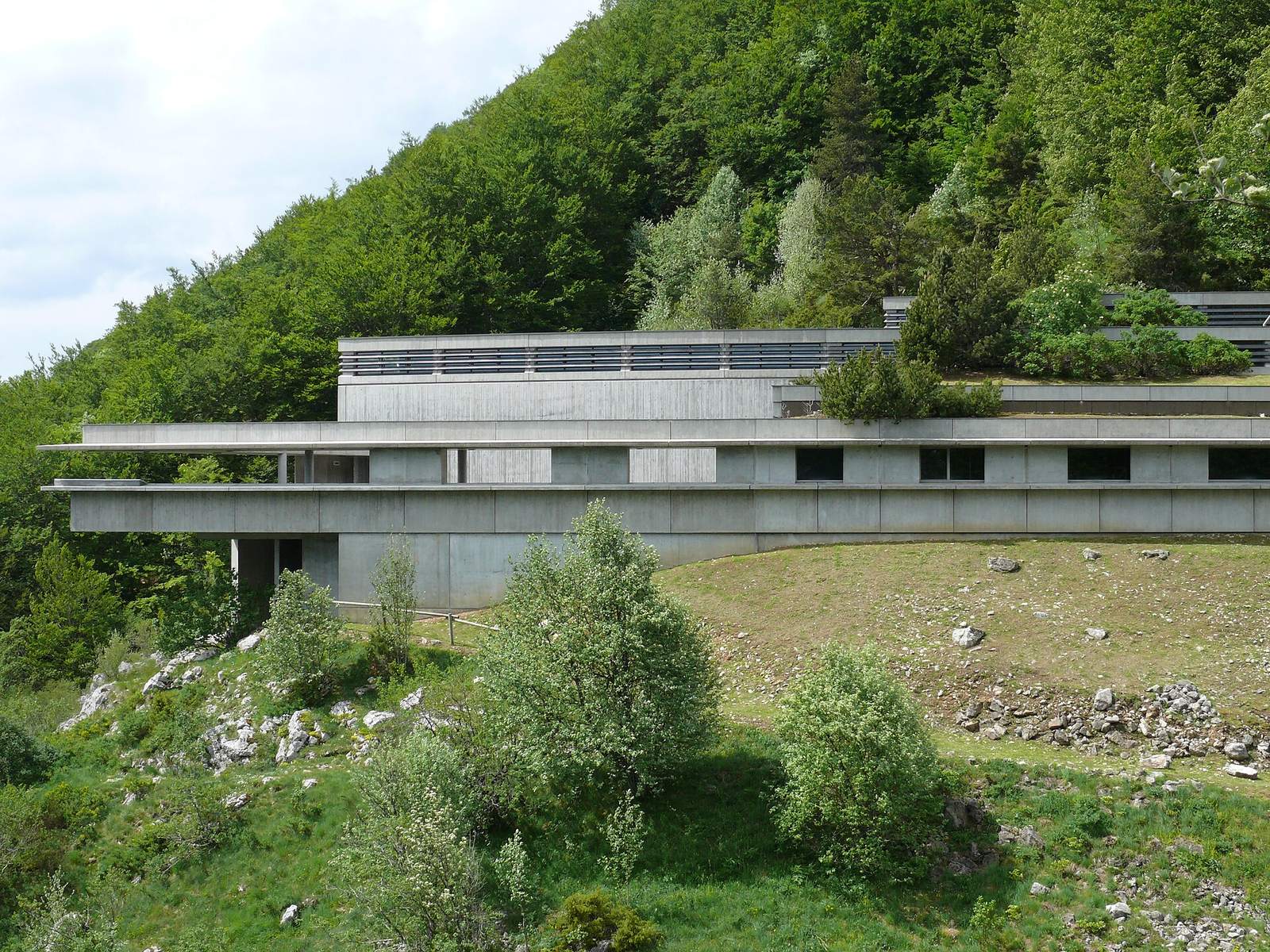 The Vercors Resistance Memorial, a long concrete building with horizontal lines set into a wooded slope at the Col de la Chau.